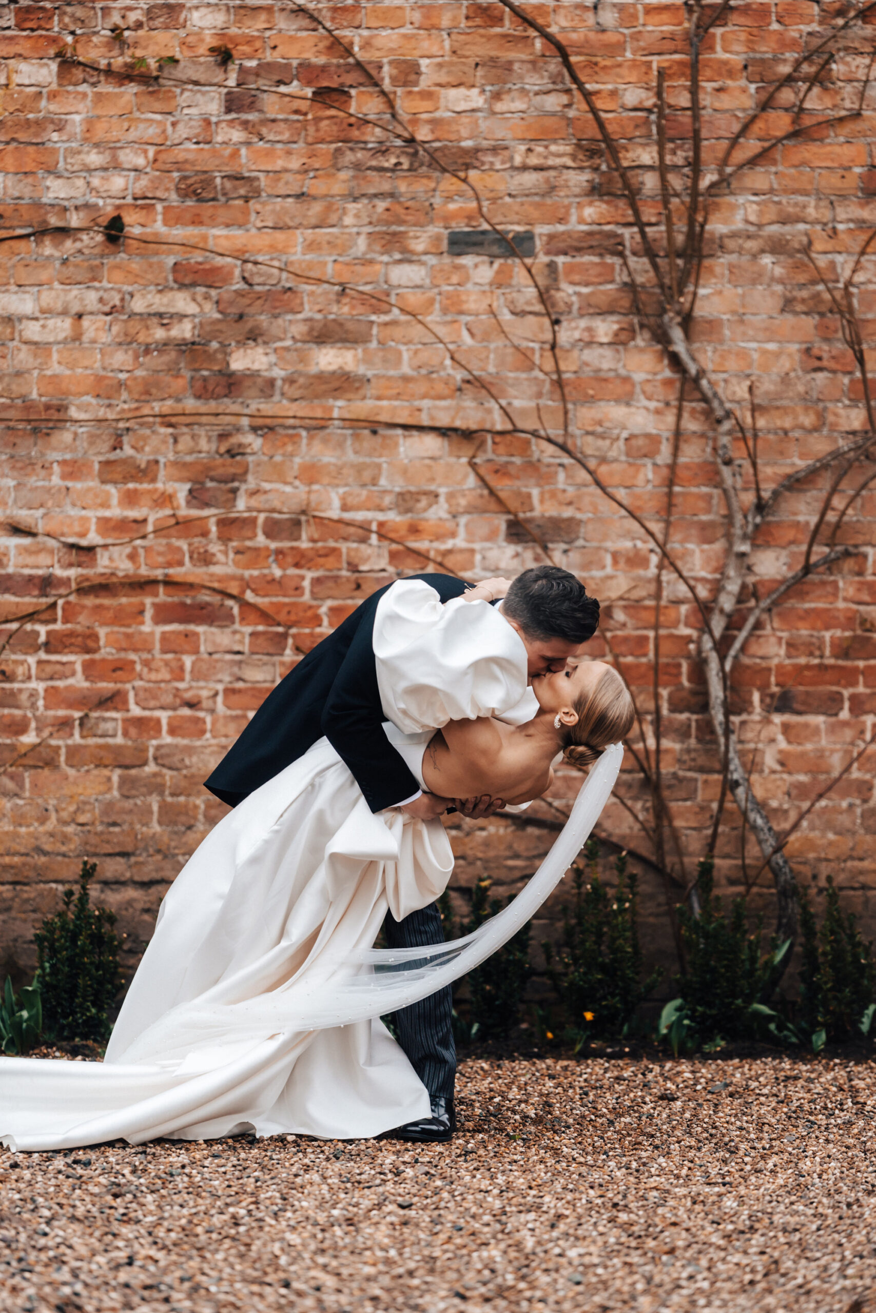 A groom leans over his wife to give her a romantic kiss