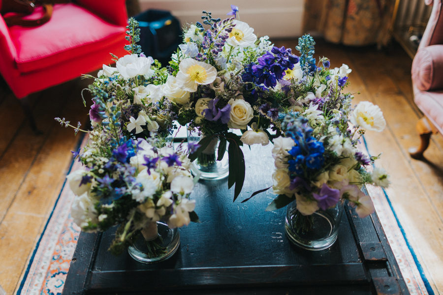 A collection of five wedding bouquets made of roses, stocks, delphiniums and foliage in purple, white and blue tones