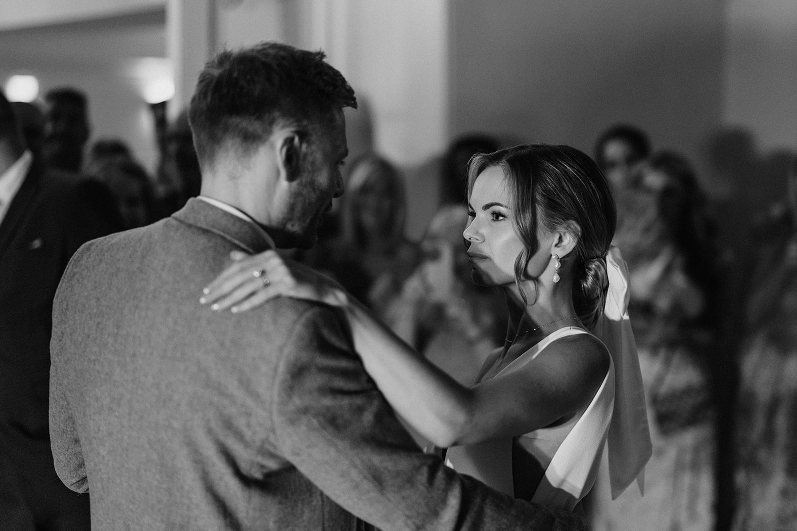 An image of a bride and groom looking at each other as they formally dance on the dance floor